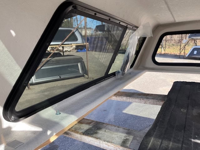 Side window of a truck with tinted glass and black frame.
