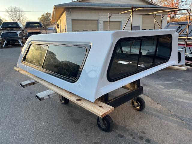 Chevy truck camper shell in summit white with tinted windows.