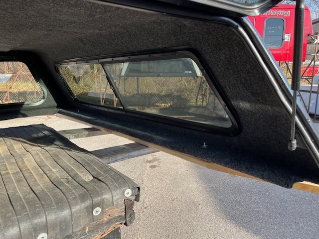 Black truck bed cover with side window for Chevy HD 82.2" model.