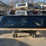 Black truck bed for GMC 1500 with PNT code 8555, outdoor setting.