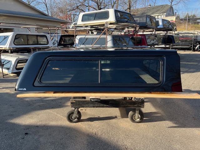 Black truck bed for GMC 1500 with PNT code 8555, outdoor setting.