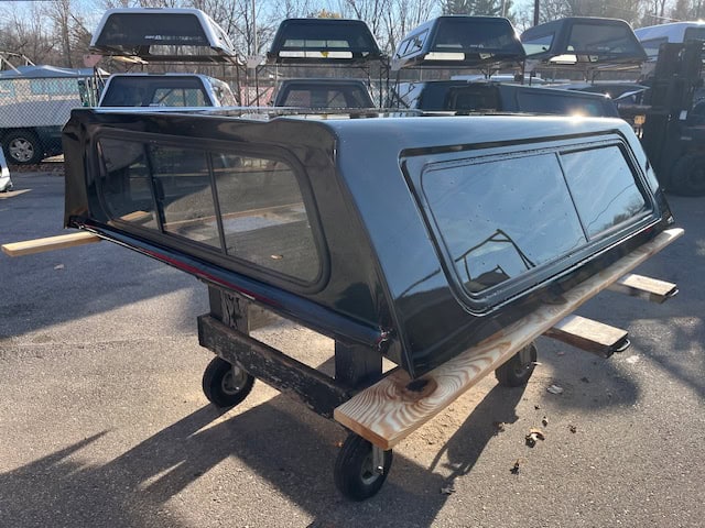 Black truck cap for GMC 1500 with tinted windows and aerodynamic design.