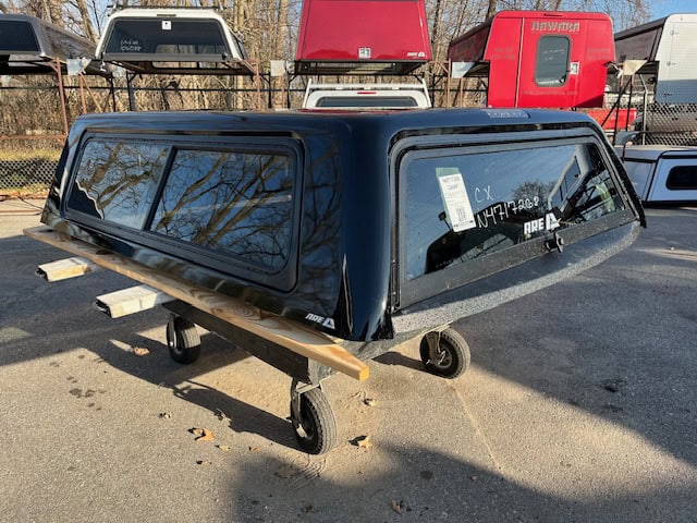 Black truck cap for GMC 1500 with tinted windows and aerodynamic design.