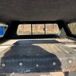 GMC 1500 truck bed with black PNT code 8555 in a truck camper shell.