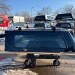 Black truck cap with side window for Ford SD 81.9" in outdoor lot.