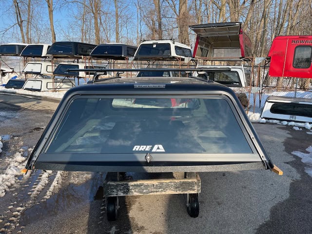 Black truck cap with window for Ford SD 81.9" in outdoor storage lot.