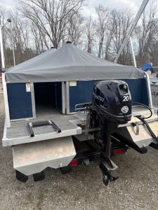 Boat with canopy and outboard motor for fishing or leisure at Camp & Cruise.
