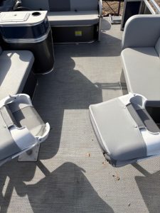 Pontoon boat deck with seating and control console.