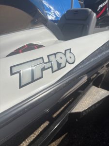 Tritoon boat with T-196 logo at Camp and Cruise, ready for water fun.