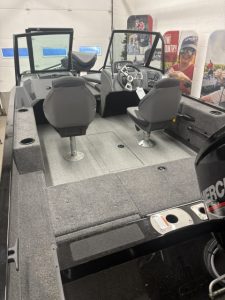 Boat cockpit with steering wheel and seating at Camp and Cruise.
