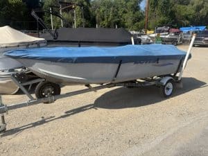 14-foot Lowe utility boat on trailer at a dealership lot.