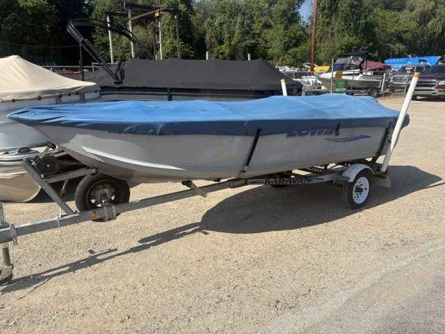 14-foot Lowe utility boat on trailer at a dealership lot.