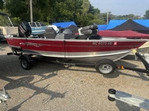 Red Lund boat with Mercury 50 engine on trailer at marina.