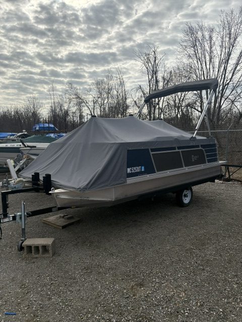 Paddle King LoPro Cruiser boat covered with a tarp on a trailer.