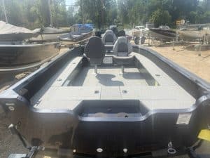 Fishing boat with seats and trolling motor at marina.
