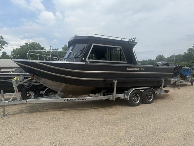Black Thunder Jet Alexis Pro boat on trailer at a dealership.