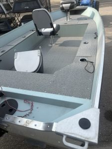 Interior view of Starcraft Patriot 16 Tiller boat with seating and fishing features.
