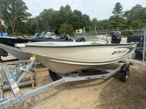 White Starcraft 14' Patriot Tiller boat on trailer at dealership.
