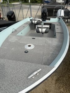 Light blue fishing boat with seats and equipment at Camp & Cruise.