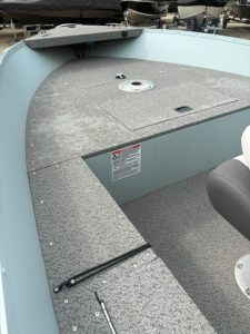 Close-up of boat deck with storage hatch and seating area.