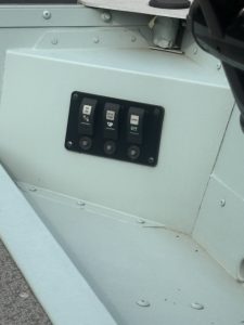 Close-up of boat electrical panel with switches for camping and boating features.