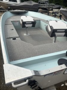 Light blue fishing boat with two seats and a flat deck for fishing or leisure.