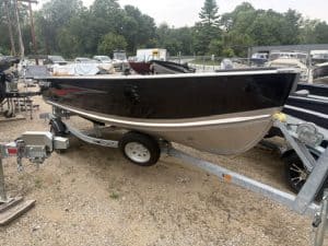 Black and white Starcraft 16 Seafarer DLX boat on trailer at marina.