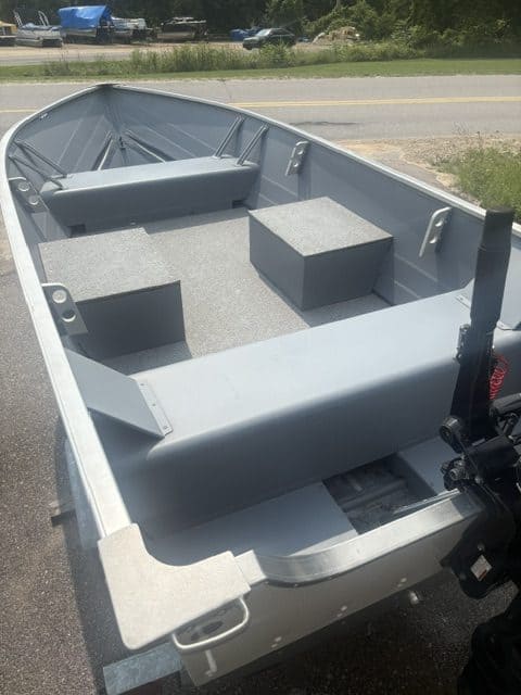 Aluminum fishing boat with seats and motor mount on trailer.