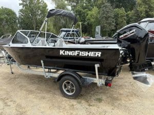 Black KingFisher boat with Mercury outboard motor on trailer.
