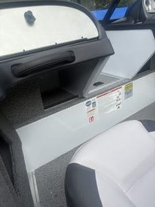 Pontoon boat interior storage compartment with lid and dashboard.