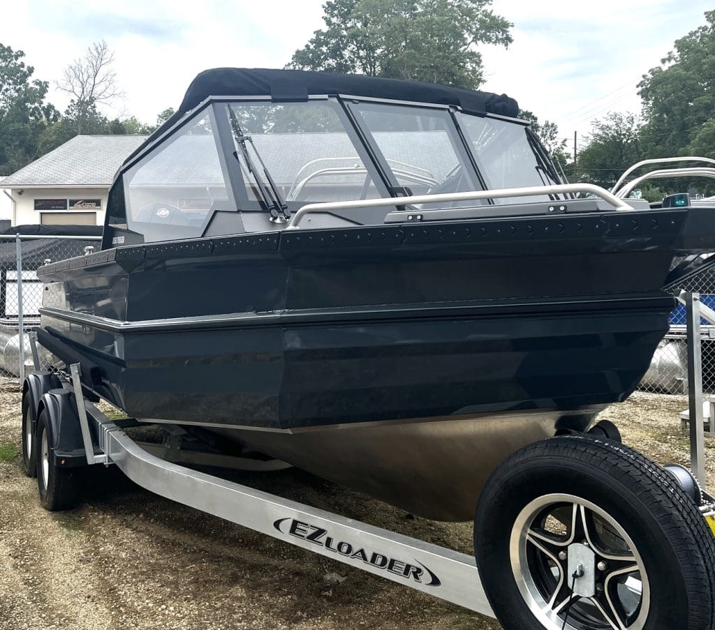 Black cabin cruiser boat on EZ Loader trailer ready for transport.
