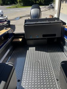 Boat interior with outboard motor and diamond plate flooring at Camp & Cruise.