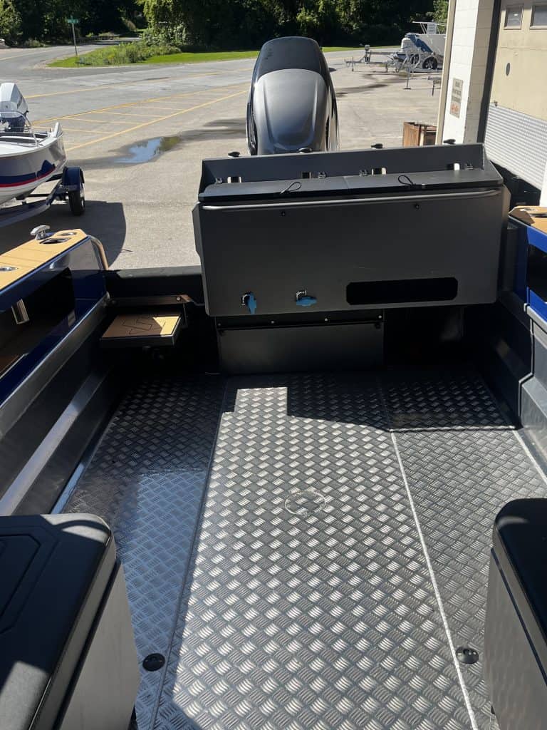 Boat interior with outboard motor and diamond plate flooring at Camp & Cruise.