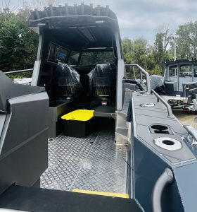 Modern marine boat with seating and control area for camping and cruising.