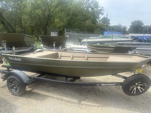 SeaArk 1448 MV fishing boat on trailer at boat dealership.