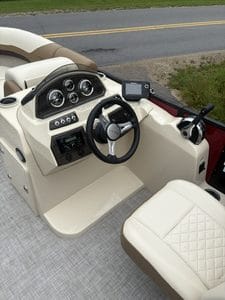 Pontoon boat dashboard with steering wheel and gauges for smooth navigation.