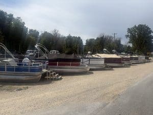 Multiple Lowe UC200 cruise pontoon boats parked on a gravel lot.