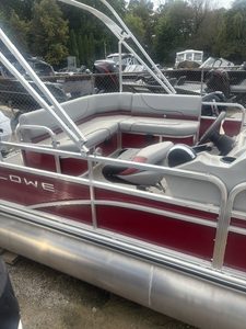 Lowe UC200 cruise pontoon boat with seating and canopy in outdoor setting.
