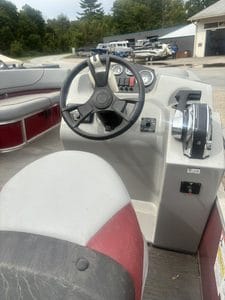 Pontoon boat dashboard with steering wheel and controls for cruise boat.