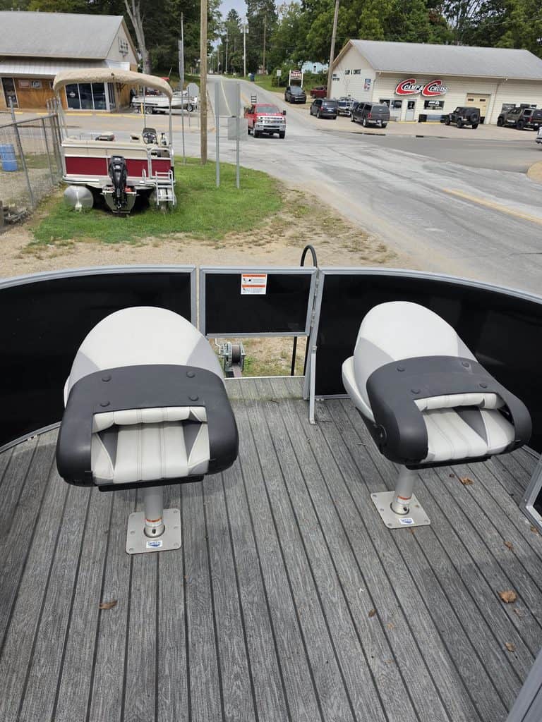 View of pontoon boat seats with a street and shops in the background.