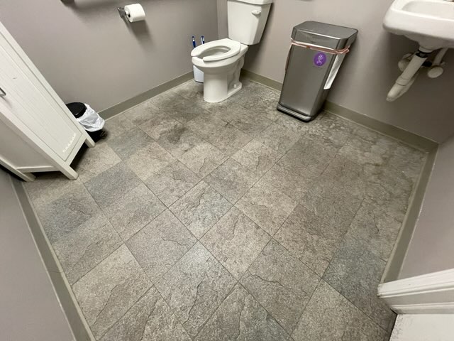Clean, restored bathroom floor with new tiles and improved appearance.
