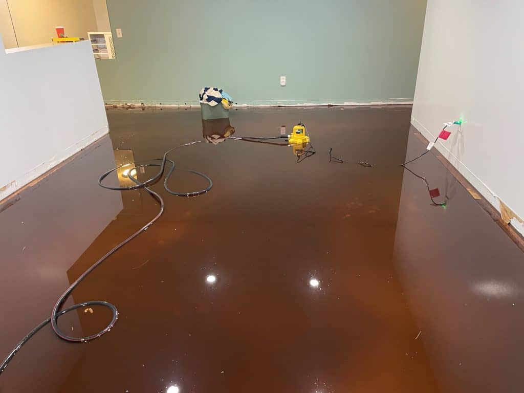 Water extraction process with equipment on wet carpet after flooding.