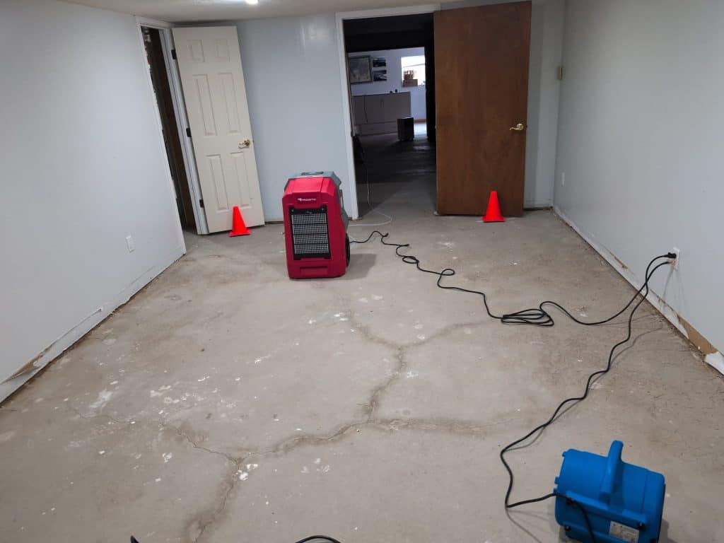 Water extraction equipment in a room during cleanup process.
