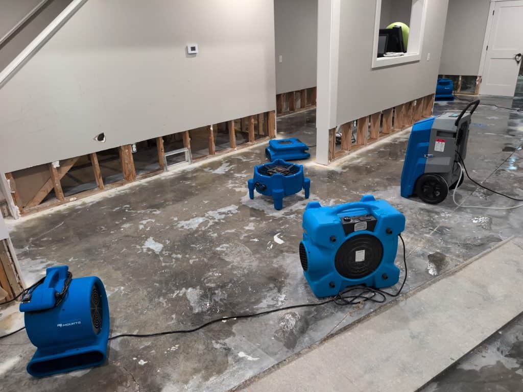 Water extraction machines on a wet floor during restoration process.