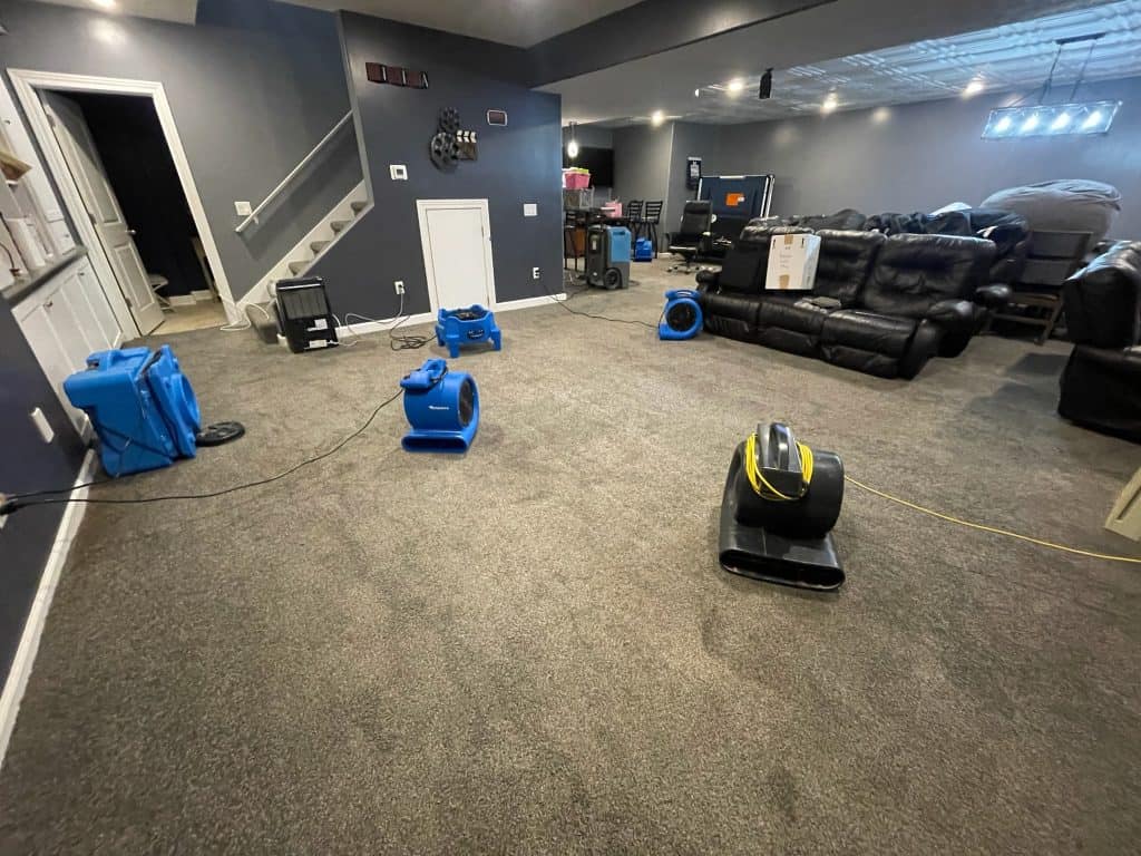 Water extraction equipment on carpet in living room after flooding.
