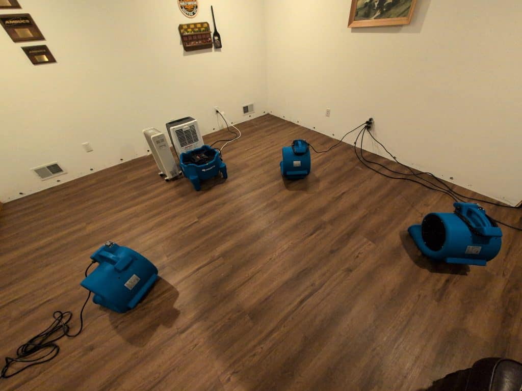 Water extraction tools on hardwood floor after water damage repair.