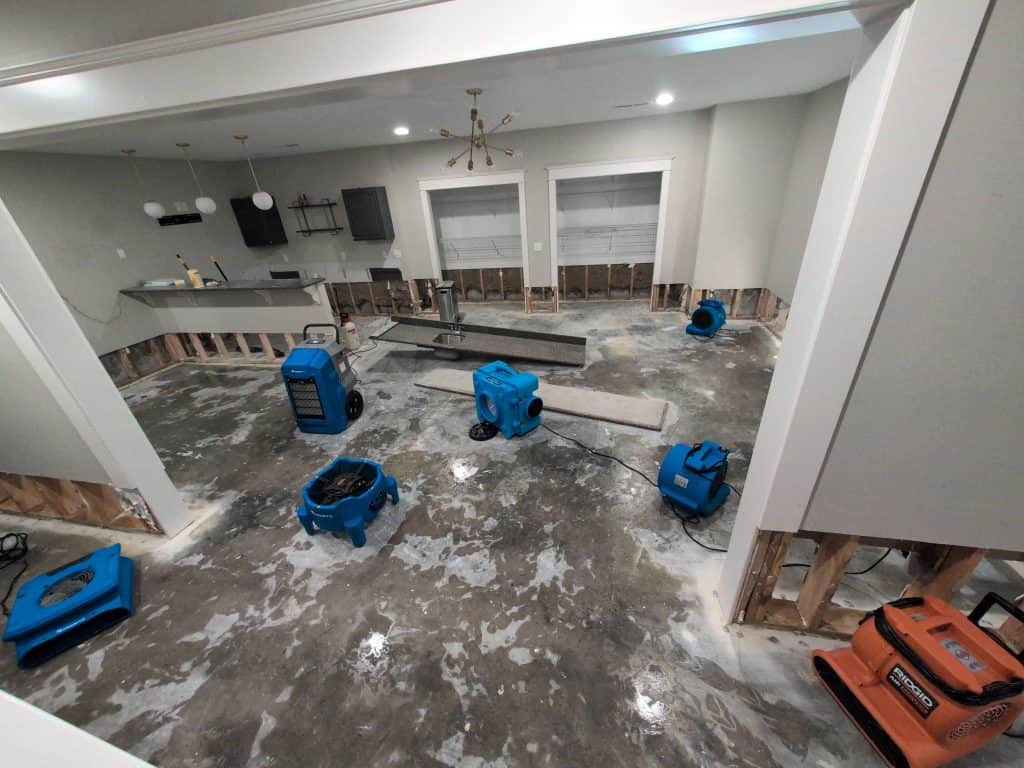 Water extraction equipment in a flooded room during cleanup process.
