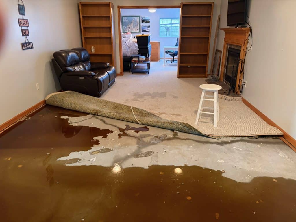 Water damage and carpet removal in living room after flooding.