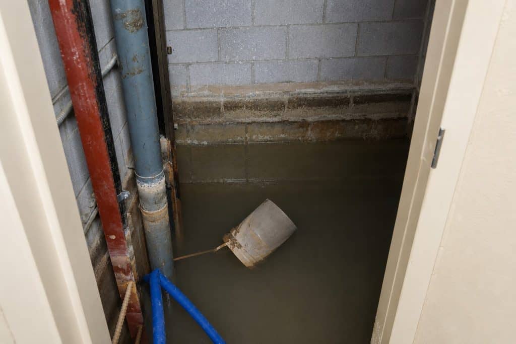 Flooded basement with water extraction equipment and pipes.