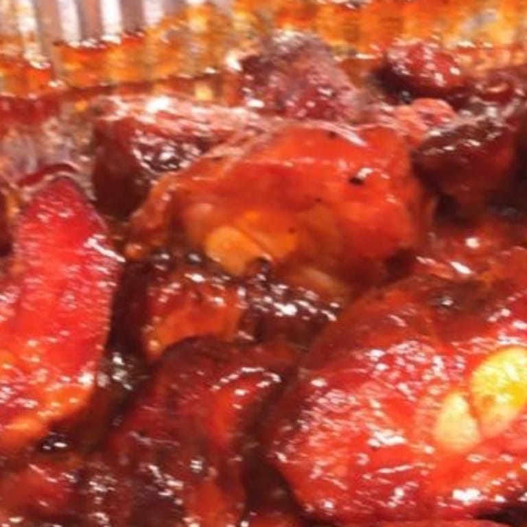 Delicious rib tips glazed with savory barbecue sauce, served with sides. Perfect for a hearty meal at Corine's Soul Food, Cakes & Catering.